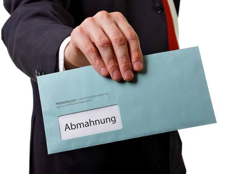 Mann hält Abmahnung in der Hand