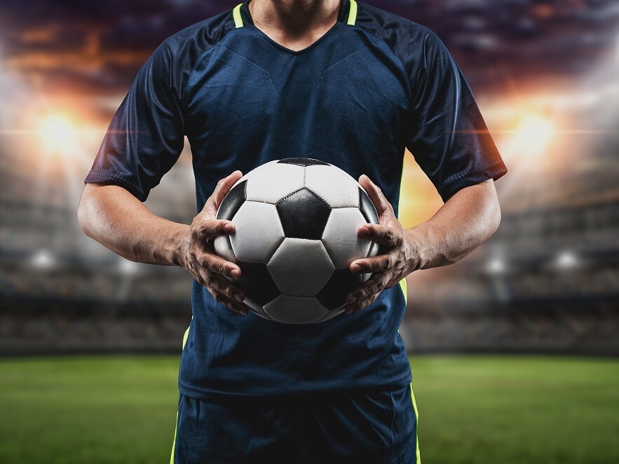 Fußballer mit Fußball im Stadion