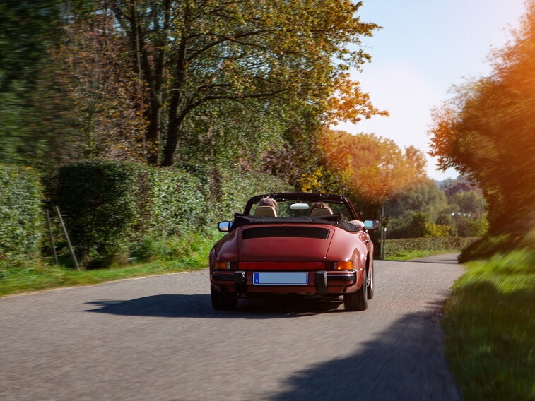 Paar fährt im Sommer mit einem Cabrio