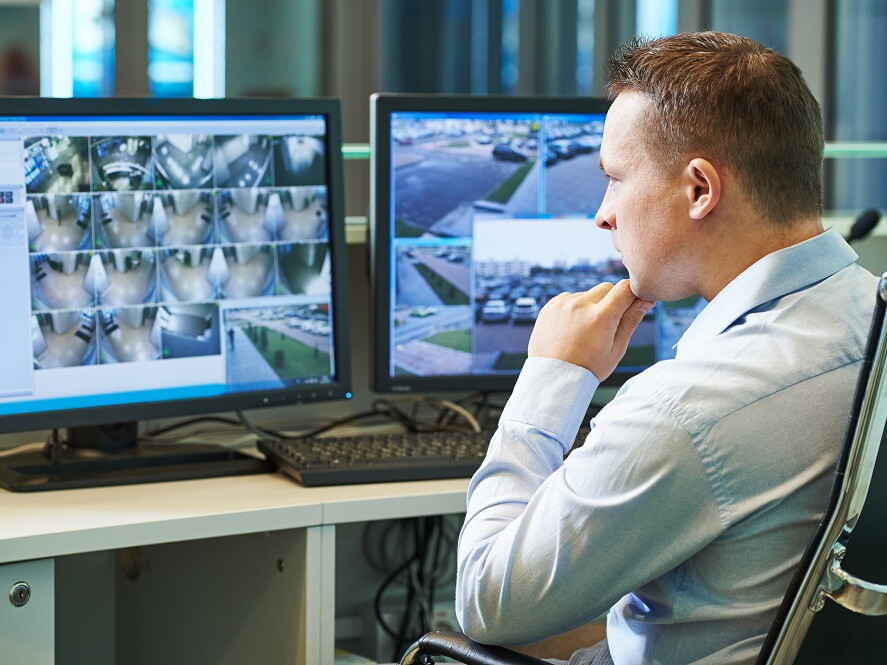 Mann in Raum mit Videoüberwachung