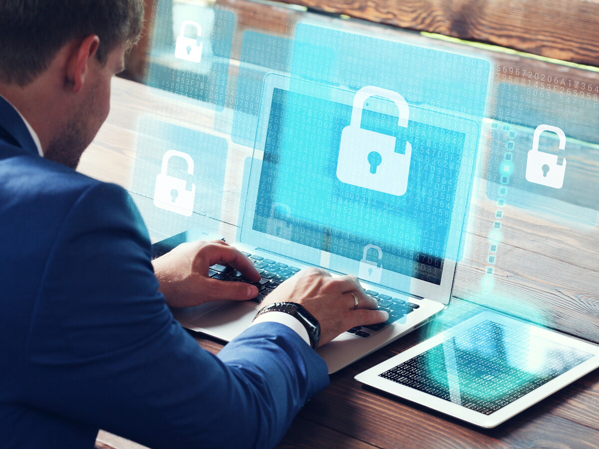 Mann am Laptop  mit Icons für digitale Sicherheit