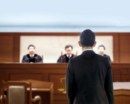 Mann im Anzug vor dem Richtertisch