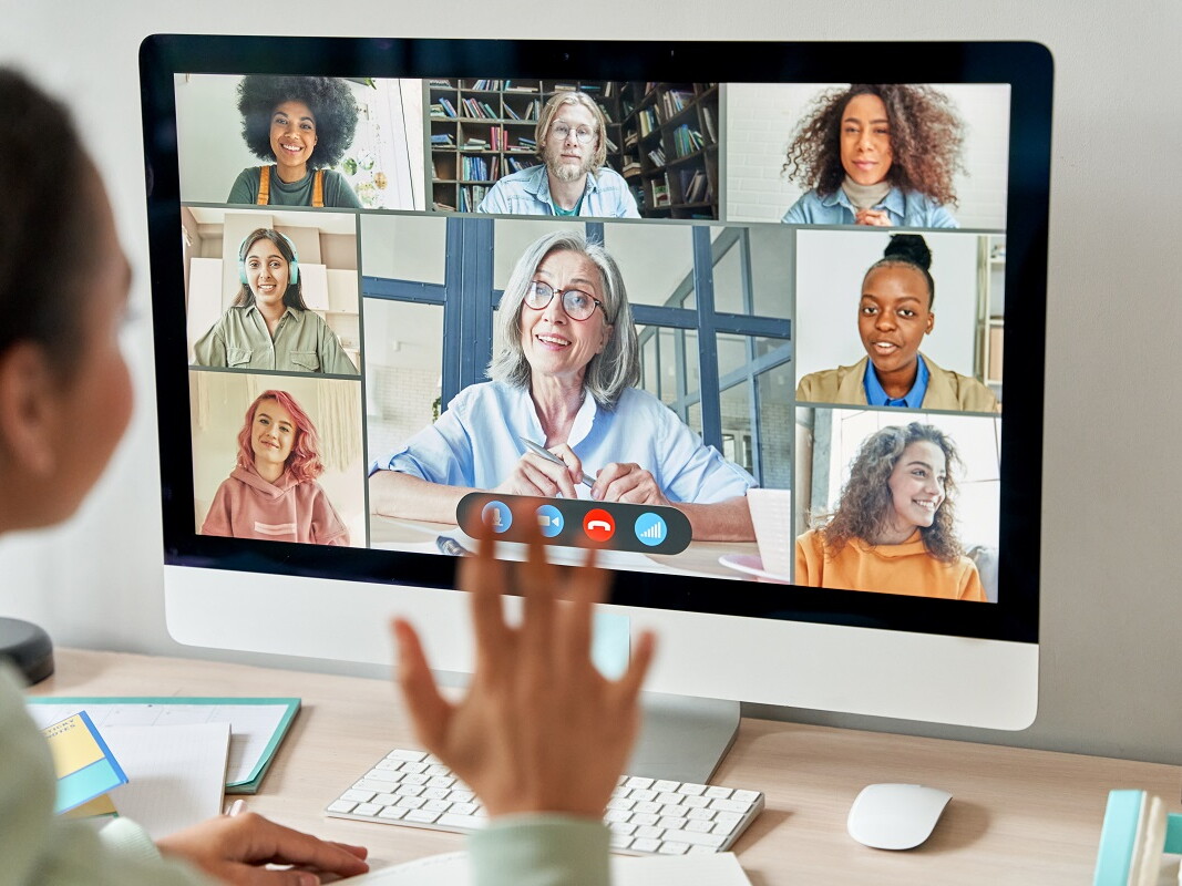 Schülerin winkt Klassenkameraden im Online Unterricht