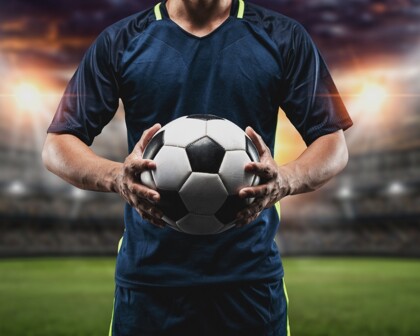 Fußballer mit Fußball im Stadion
