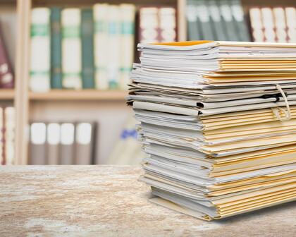 Aktenstapel vor Bücherschrank