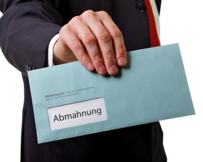 Mann hält Abmahnung in der Hand