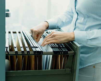 Frau blättert im Archiv in Akten