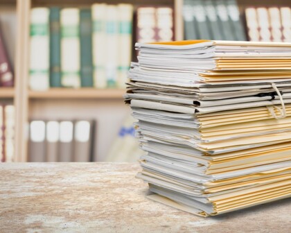 Aktenstapel vor Bücherschrank
