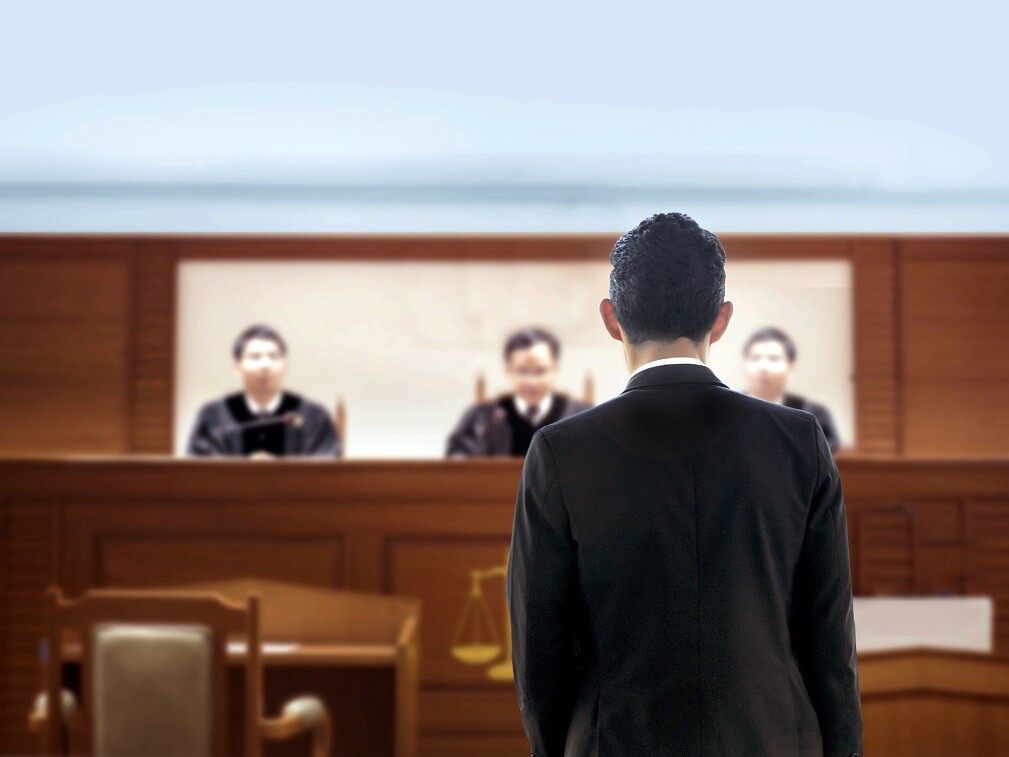 Mann im Anzug vor dem Richtertisch
