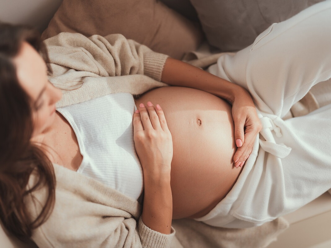 Schwangere Frau hält ihren Bauch