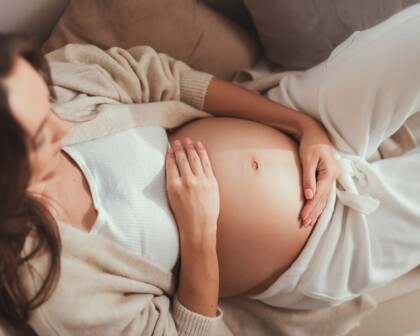 Schwangere Frau hält ihren Bauch