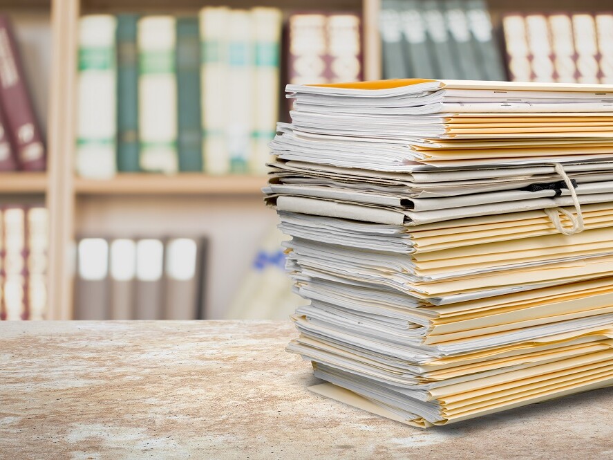 Aktenstapel vor Bücherschrank
