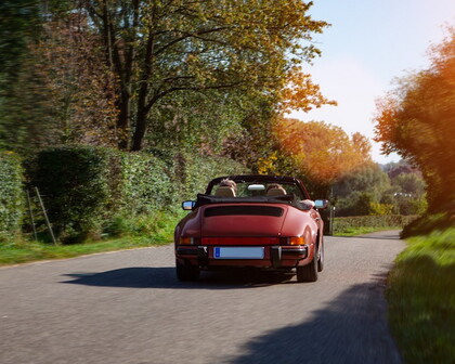 Paar fährt im Sommer mit einem Cabrio
