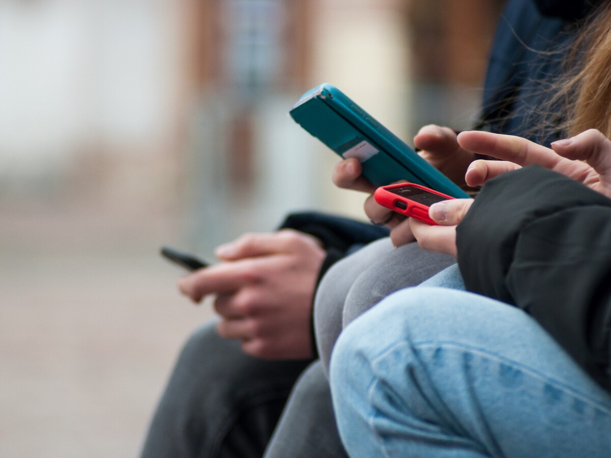 Junge Personen nutzen einen Social-Media-Feed auf dem Smartphone